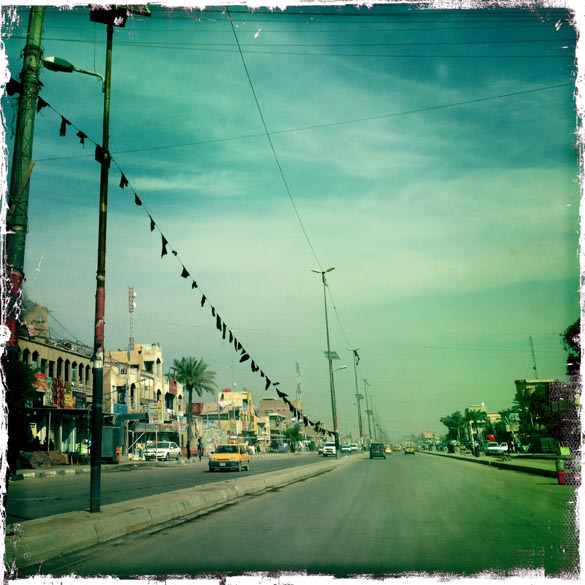 Carros em uma rua de um bairro pobre da capital iraquiana Bagdá