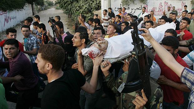 Palestinos carregam corpo de militante morto em Gaza