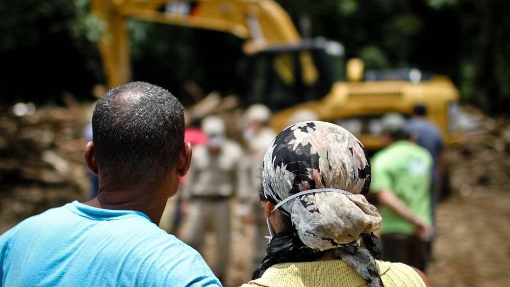 Providências depois da tragédia: casal assiste, no Vale do Cuiabá, em Itaipava, ao movimento de operários nos escombros