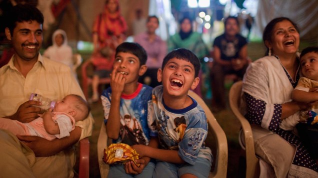 Crianças paquistanesas riem dos artistas circenses da trupe do Jan Baz Circus