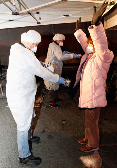 Oficial mede nível de radiação em jovem que evacuou a área perto da usina nuclear de Fukushima, no Japão Oficial mede nível de radiação em jovem que evacuou a área perto da usina nuclear de Fukushima, no Japão