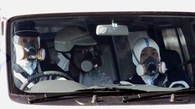 Policiais patrulham a área atingida pela usina nuclear em Fukushima, no Japão