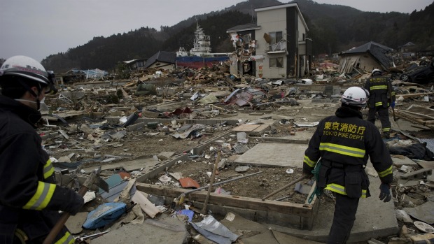 Bombeiros japoneses trabalham na busca de sobreviventes em meio aos destroços causados pelo terremoto de 11 de março