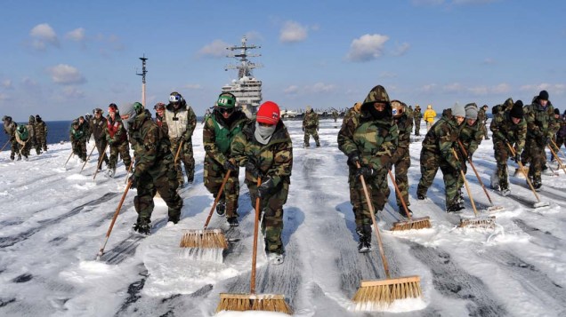 Soldados da marinha americana limpam o porta-aviões Ronald Reagan, que participa das operações de resgate na costa nordeste do Japão, para eliminar o possível contaminação radioativa