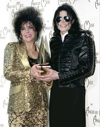 Com a atriz, e amiga, Elizabeth Taylor, após premiação em 1993. Na ocasião o astro vestiu uma jaqueta de couro