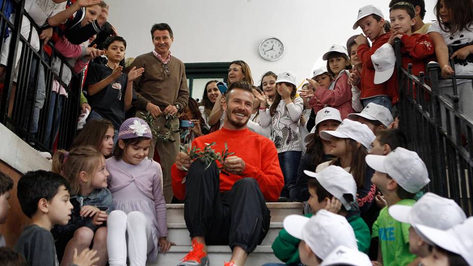 O jogador inglês de futebol, David Beckham, visita alunos de escola primária em Atenas, na Grécia, um dia depois da cerimónia de passagem da chama olímpica