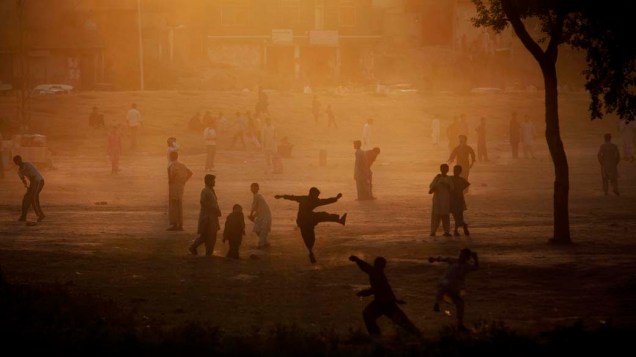 Paquistaneses jogam críquete em parque na cidade de Islamabad