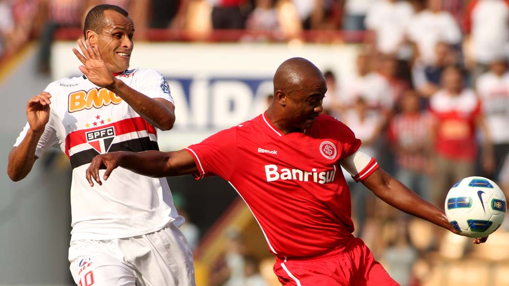 O jogador Rivaldo do São Paulo disputa a bola com o jogador Kleber do Internacional durante partida válida pelo Campeonato Brasileiro realizado na Arena Barueri