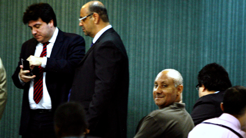 Principal acusado da morte da juíza Patrícia Acioli, o tenente-coronal Cláudio Luiz Oliveira, sentado, sorri durante a audiência
