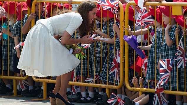 Kate Middleton se abaixa para receber presente de criança durante visita ao Jardim Botânico, em Cingapura . Ela está no país com o marido, príncipe William, em razão de visita oficial de dez dias ao sudeste asiático