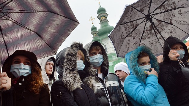 Ucranianos usam máscaras durante um protesto na capital Kiev, nesta terça-feira (13), onde exigem um aumento do financiamento de tratamento de doenças, como Aids e hepatite