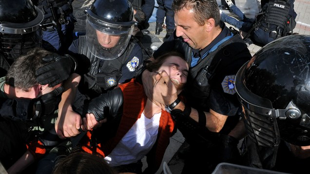 Oficiais de polícia detém um membro da oposição durante protesto em Kosovo, contra um acordo para privatizar a distribuição de energia elétrica no país