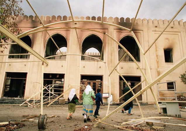 Moradores do Kuwait andam entre prédios danificados pela Guerra do Golfo