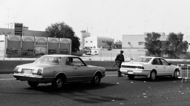 Soldado iraquiano fiscaliza carros em posto de controle na cidade do Kuwait, durante a invasão iraquiana ao país