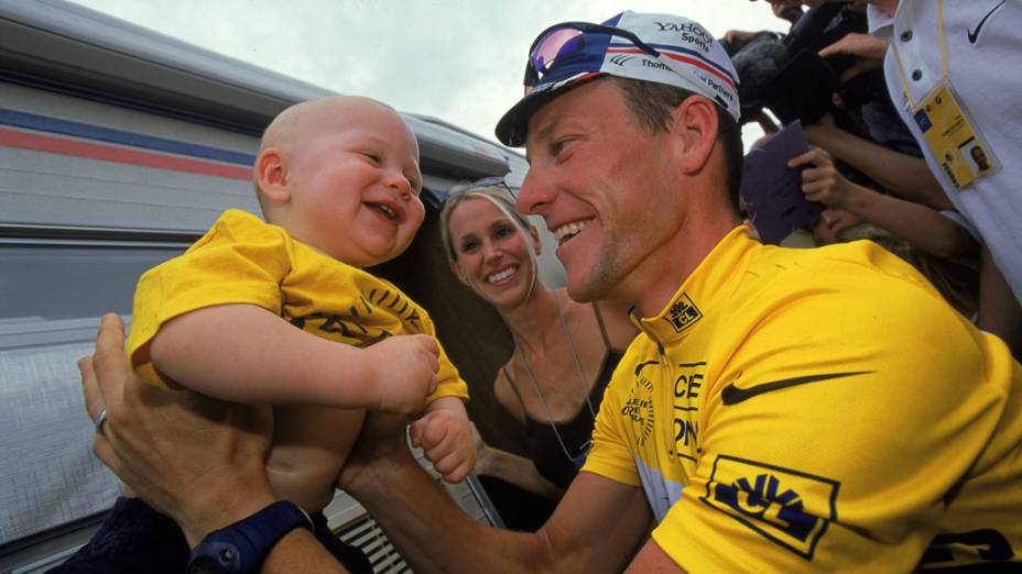 Lance Armstrong segura seu filho, Luke, com sua esposa, durante Tour de France de 2000