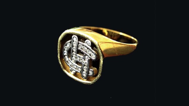 Anel de ouro 18 quilates com as iniciais de Clodovil Henandes formadas por 25 pedras de brilhantes