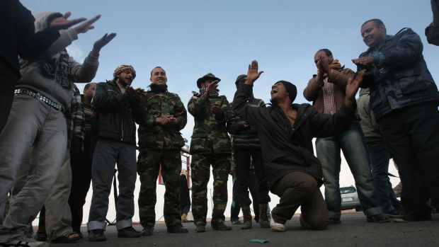 Rebeldes fazem danças tradicionais antes de deixar Ajdabiya para combate em Brega