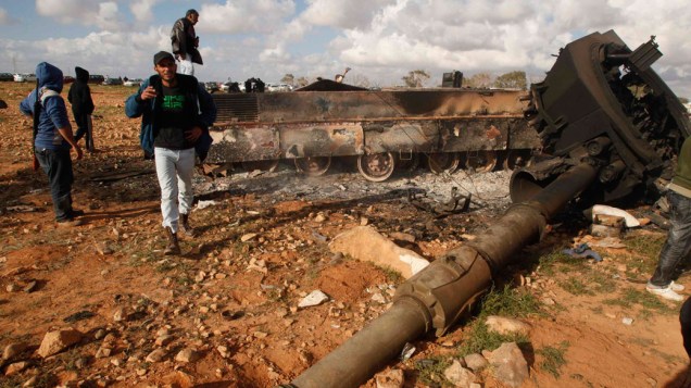 Rebeldes observam destroços de tanque atingido por ataque aéreo