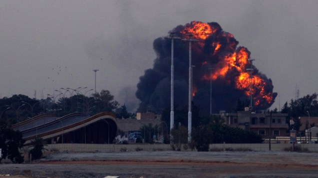 Explosão é vista próxima a cidade de Bengasi, após caça do governo de Muamar Kadafi ser derrubado por rebeldes