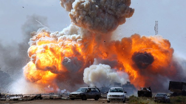 Veículos das forças leais do líder Muamar Kadafi explodem após ataque aéreo em estrada que liga Bengasi e Ajdabitah, na Líbia