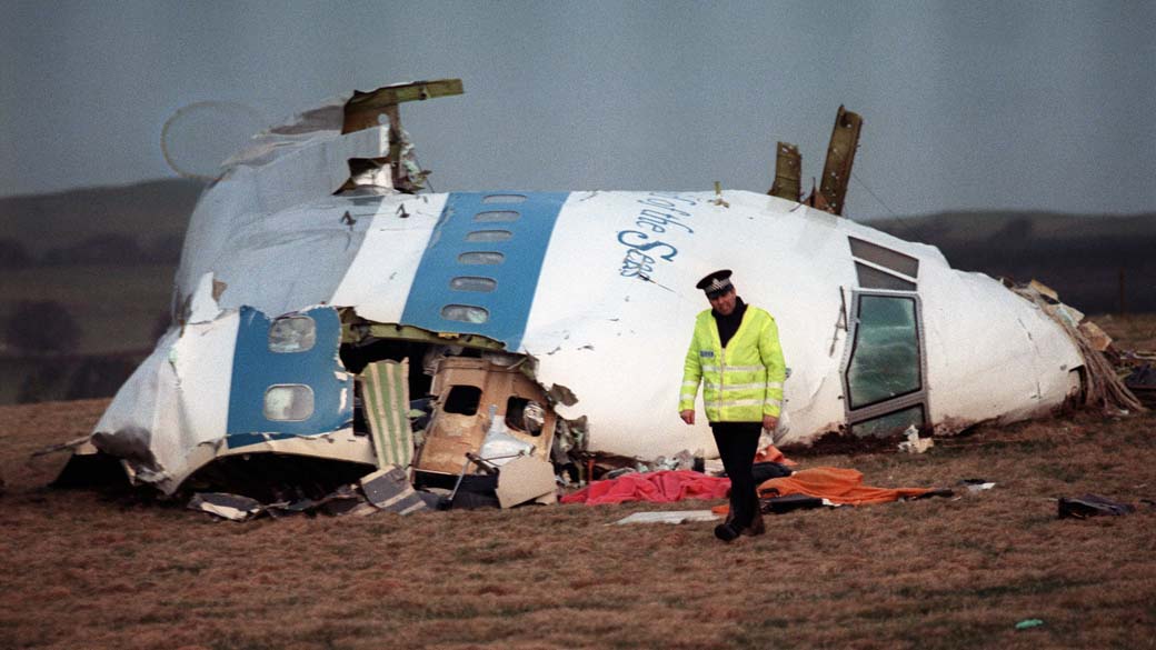 Policial em frente aos destroços do vôo Pan Am 747, em Lockerbie.
