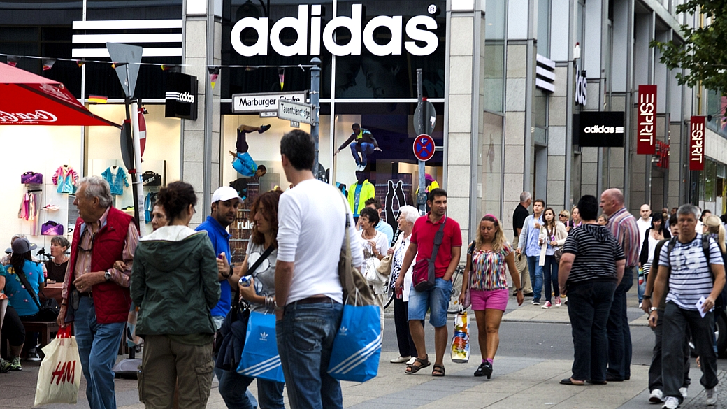 Pessoas caminham em frente a uma loja da alemã Adidas em Berlim