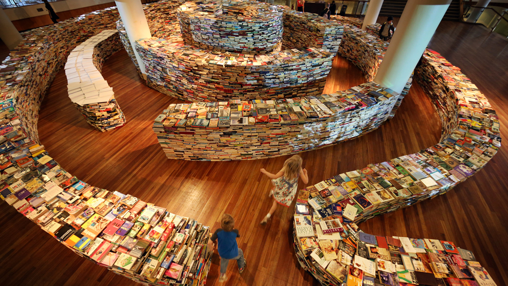 Visitantes desfrutam da instalação 'aMAZEme', um labirinto feito com livros no Southbank Centre em Londres, Inglaterra