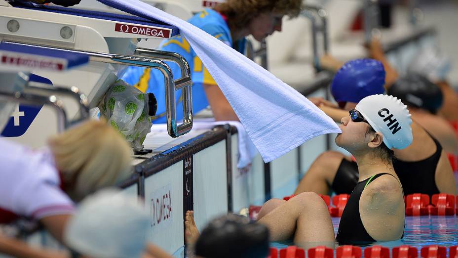 A nadadora chinesa Lu Dong morde uma toalha e se prepara para o início da prova de 100 m costas, na categoria S6