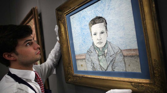 Funcionário da casa de leilões Sotheby segura o Boy on a Sofa, quadro do pintor Lucian Freud, avaliado em 1,5 milhão de libras, maior valor já pago a uma pintura em papel do artista