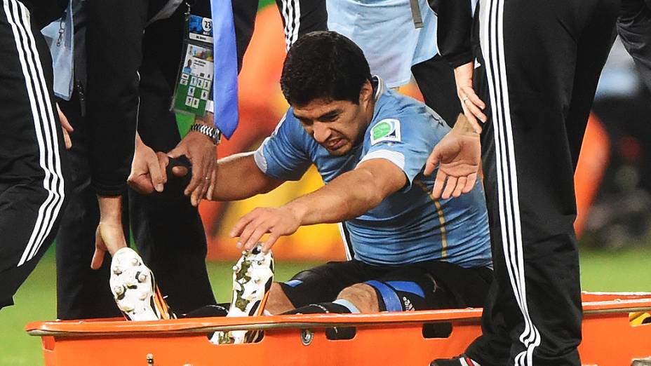 O uruguaio Luis Suárez é levado de maca para fora do campo para receber tratamento, após sofrer falta no jogo contra a Inglaterra no Itaquerão, em São Paulo
