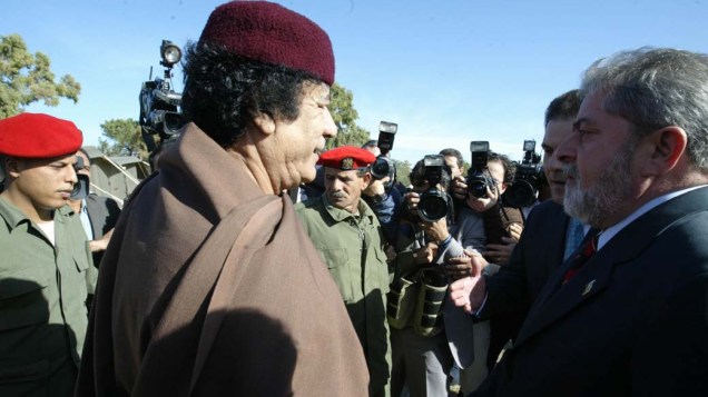 O ENCONTRO: Presidente Lula é recepcionado pelo presidente da Líbia, coronel Muamar Kadafi em Trípoli, em 10 de dezembro de 2003 <br>FICHA CORRIDA DO DITADOR:  Acusado de apoiar o terrorismo, Kadafi chefia há 41 anos um dos governos mais corruptos do mundo, segundo a ONG Transparência Internacional. Neste ano, expulsou da Líbia a organização da ONU que prestava socorro humanitário a milhares de refugiados e pessoas que solicitavam asilo no país. Ao ditador, Lula não economizou cumprimentos: chamou-o de "amigo" e "irmão".