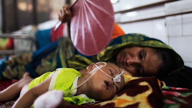 Mãe tenta amenizar do calor com um leque, o filho de seis meses durante corte de energia no Dhaka Medical College Hospital em Dhaka, Bangladesh
