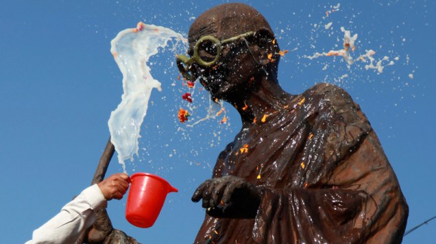 Indiano lava a estátua de líder indiano Mahatma Gandhi, que completaria 141 anos neste sábado