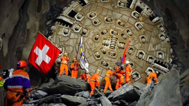Mineiros celebram após uma furadeira gigante ter concluído o maior túnel do mundo sob os Alpes Suíços. Construída durante 15 anos, a passagem tem 57 quilômetros de extensão