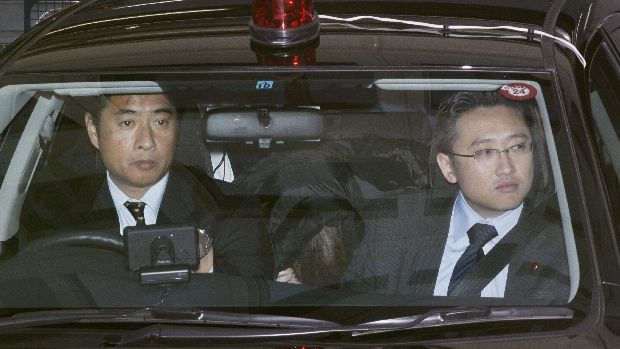 Policiais escoltam o terrorista Makoto Hirata, abaixado no banco traseiro do carro