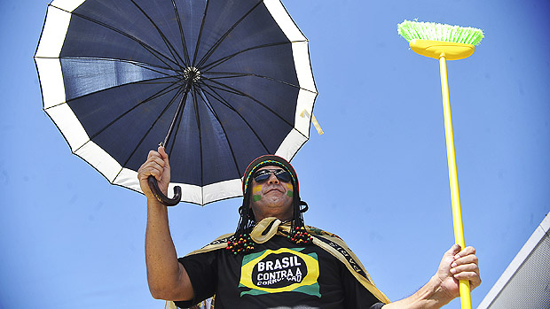 Manifestante com guarda-chuva e vassoura durante marcha contra a corrupção, na Esplanada dos Ministérios