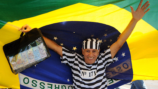Participante embaixo da bandeira do Brasil, em marcha contra a corrupção, na Esplanada dos Ministérios