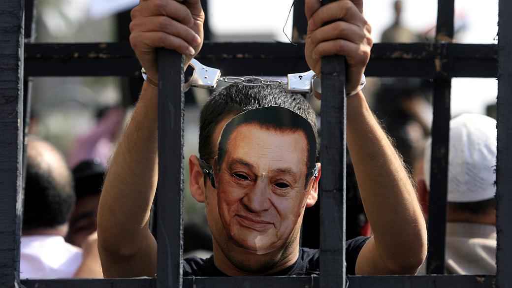 Manifestante com uma máscara do ex-ditador egípcio Hosni Mubarak participa de um protesto no Cairo, em 8 de abril de 2011. Os jovens montaram uma cela para representar o desejo de que Mubarak fosse preso
