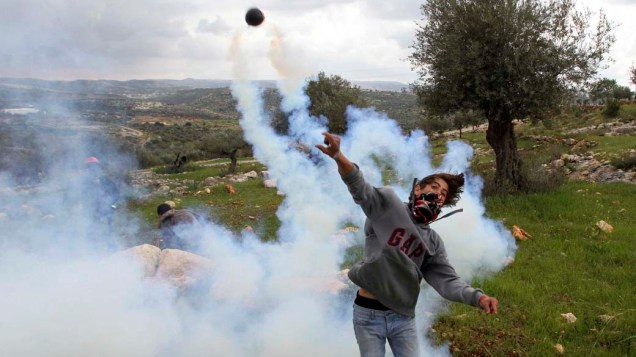 Manifestante palestino em conflito com a Força de Segurança Israelense, na Cisjordânia