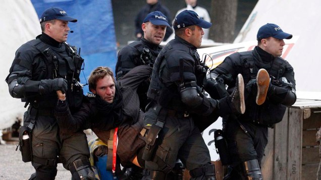 Policiais carregam manifestante do "Occupy Paradeplatz" em Zurique, na Suíça