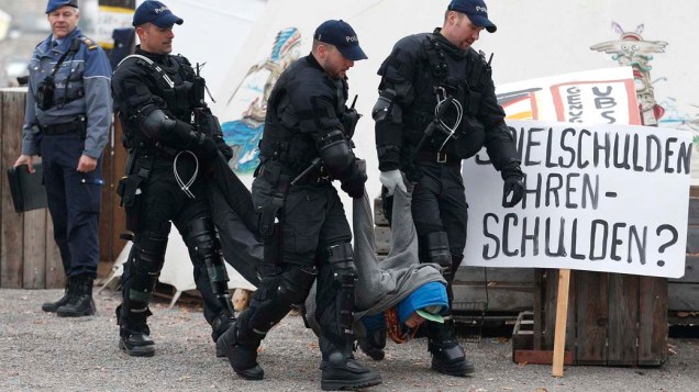 Policiais carregam manifestante do "Occupy Paradeplatz" em Zurique, na Suíça