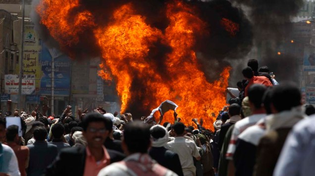 Manifestantes queimam carro durante protesto contra o governo na cidade de Sanaa, Iêmen