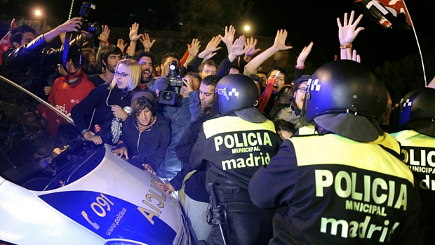 Manifestantes bloqueiam um carro de polícia em Madri durante greve geral