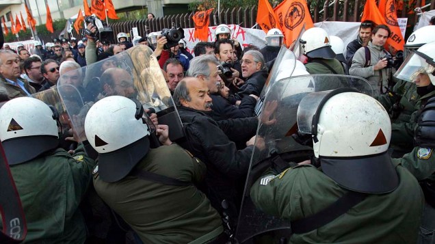 Polícia tenta conter manifestantes que protestavam diante de fornecedora de energia contra novo imposto, parte das medidas de austeridade, em Atenas, na Grécia