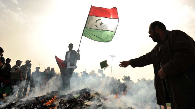 Manifestante líbio queima o “Livro Verde”, escrito pelo ditador Muamar Kadafi, durante protesto na cidade de Benghazi