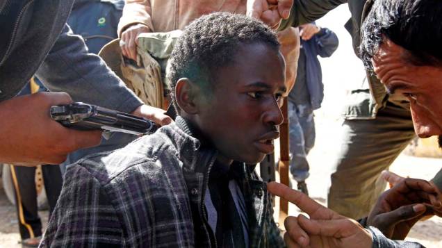 Manifestantes interrogam garoto acusado de apoiar o ditador Muamar Kadafi, entre as cidades de Brega e Ras Lanuf, na Líbia
