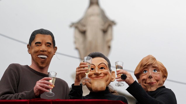Manifestantes com máscaras do presidente americano Barack Obama, do presidente francês Nicolas Sarkozy e da chanceler alemã Angela Merkel, durante protesto contra a globalização e o G20 em Nice, França