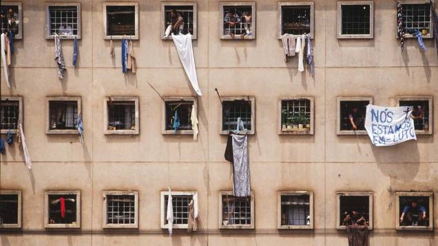 Presos nas janelas da Casa de Detenção de São Paulo, com faixa de protesto pela morte de 111 presos do Pavilhão 9, em 05/10/1992