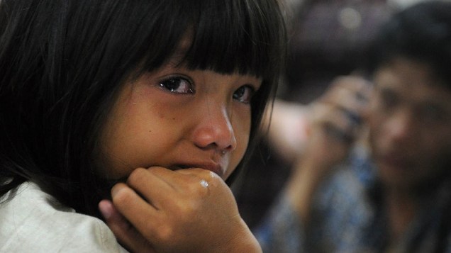 Criança chora e espera informações do avião desapareceu na quarta-feira (9) com 46 passageiros. Equipes de resgate procuram sobreviventes