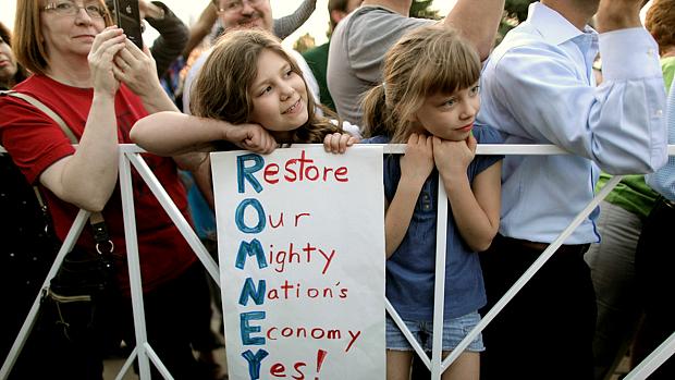 Menina exibe cartaz no qual as iniciais de Romney formam: "Restaure a economia de nossa poderosa nação"